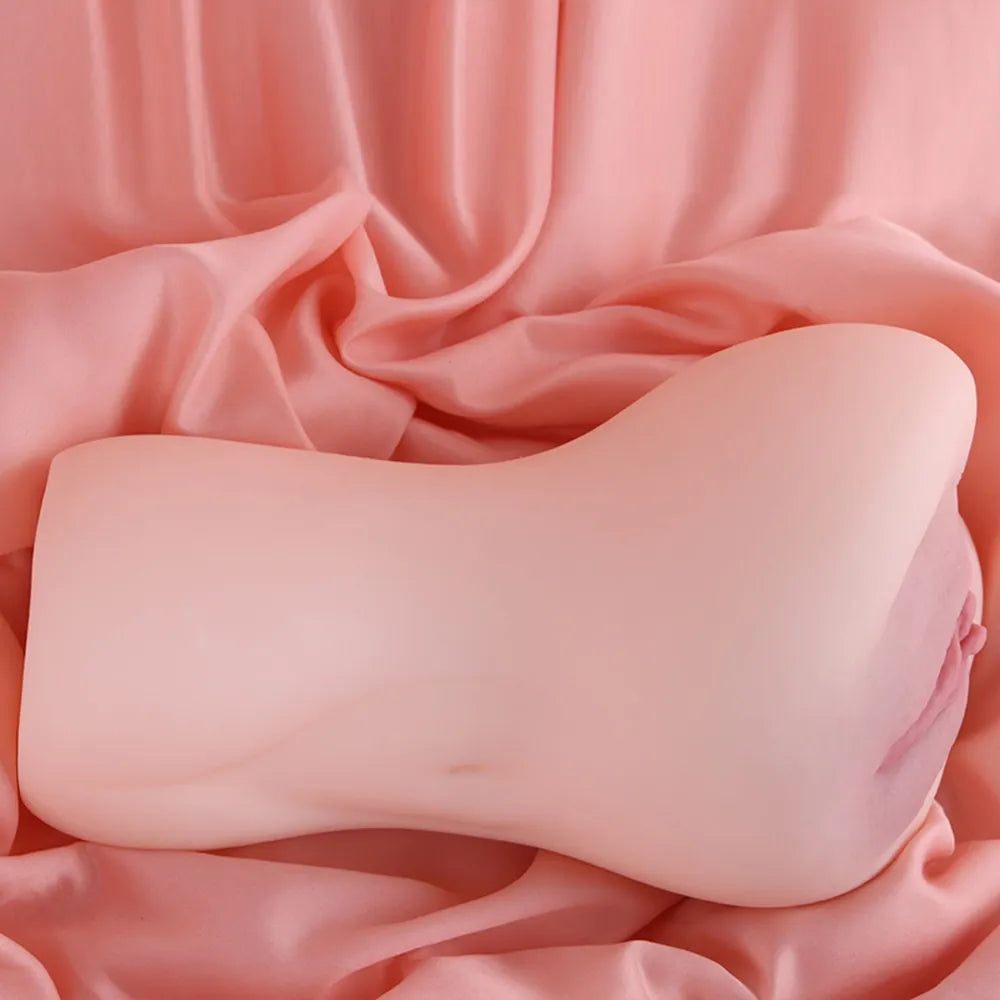 Realistic pink silicone male masturbator with smooth texture, resting on satin fabric