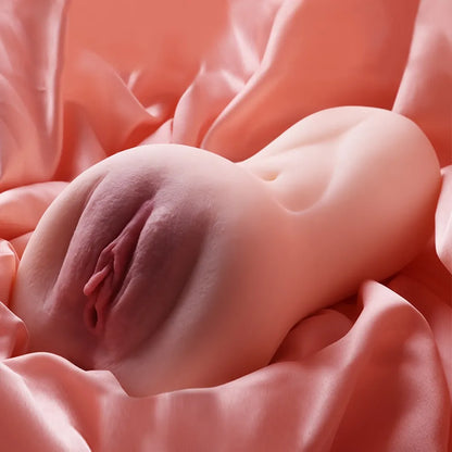 Realistic female anatomy replica with soft skin texture, nestled on satin fabric for intimate use.