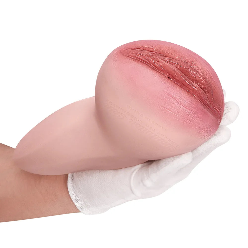 Realistic pink silicone male masturbator with detailed labia texture, held in gloved hand